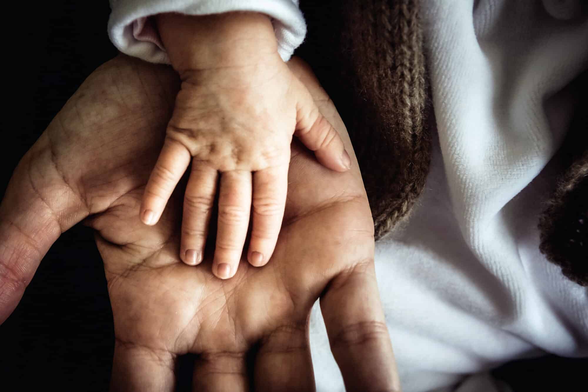 Main d'un enfant sur celle d'un adulte